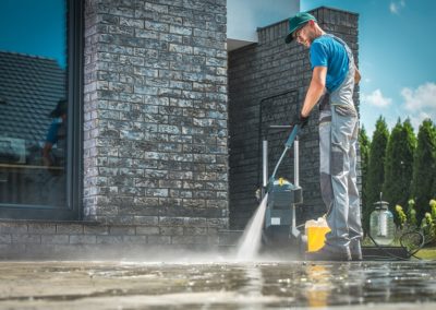 Pressure Washer Cleaning In Front Of The House. Caucasian Men In